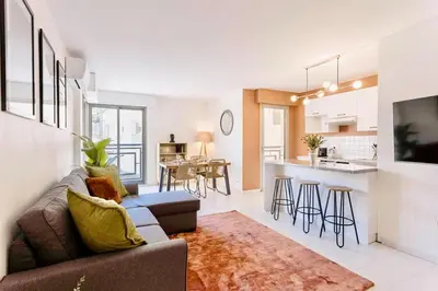 a living room with a couch and a kitchen at Le Calmette - Logement Confort Centre Cannes in Cannes