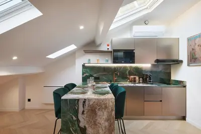a kitchen with a table with chairs and a counter top at Le XV Cannes in Cannes