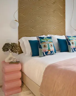 a bedroom with a bed with blue pillows and a headboard at Le XV Cannes in Cannes