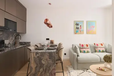 a kitchen and living room with a table and a couch at Le XV Cannes in Cannes