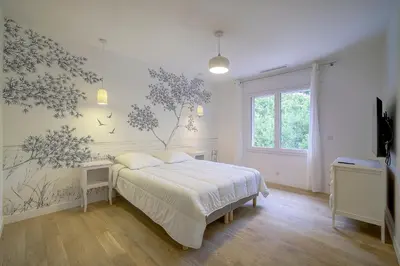 a white bedroom with a bed and a window at Villa rénovée- Vue mer- Centre de Cannes in Cannes