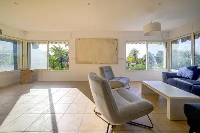 a living room with a couch and a table and chairs at Villa rénovée- Vue mer- Centre de Cannes in Cannes
