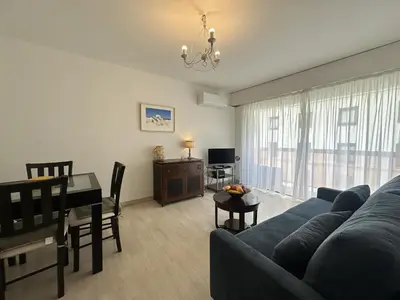 a living room with a blue couch and a table at Charmant 2P Cannes PEL1900 in Cannes