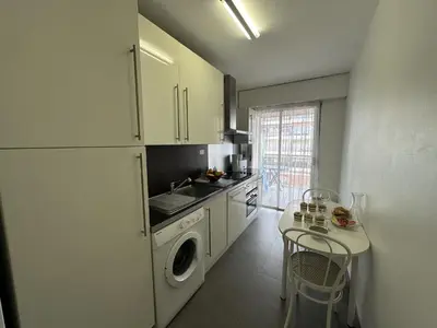 a kitchen with a washing machine and a table at Charmant 2P Cannes PEL1900 in Cannes