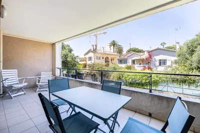 a balcony with a table and chairs and a view at Charming apartment with balcony-pool - Cannes in Cannes