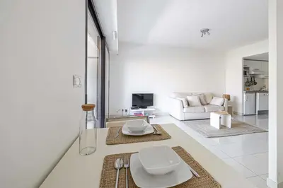 a white living room with a couch and a table at Charming apartment with balcony-pool - Cannes in Cannes