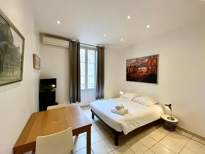 a bedroom with a bed and a table and a dining room at Viva Riviera Residence Rue Florian close Croisette in Cannes
