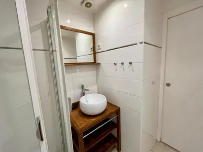 a white bathroom with a sink and a mirror at Viva Riviera Residence Rue Florian close Croisette in Cannes
