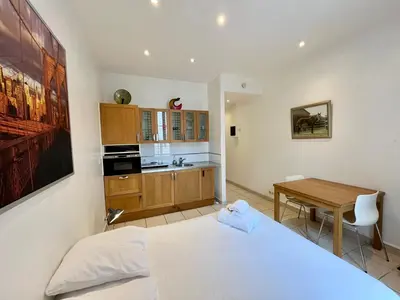 a bedroom with a bed and a desk and a kitchen at Viva Riviera Residence Rue Florian close Croisette in Cannes