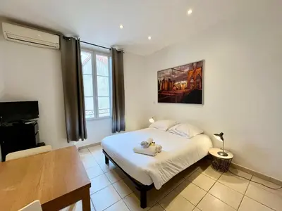 a bedroom with a white bed and a table at Viva Riviera Residence Rue Florian close Croisette in Cannes