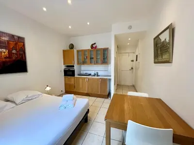 a bedroom with a bed and a table and a kitchen at Viva Riviera Residence Rue Florian close Croisette in Cannes