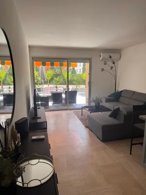 a living room with a couch and a table at Парк Круазет , Апартаменты 3 комнаты , с террасой и паркингом , in Cannes
