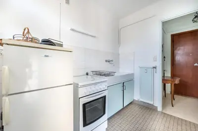 a white kitchen with a stove and a refrigerator at A056 - Nice Studio Cannes centre with parking in Cannes