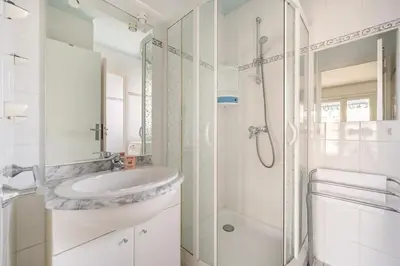 a white bathroom with a sink and a shower at A056 - Nice Studio Cannes centre with parking in Cannes