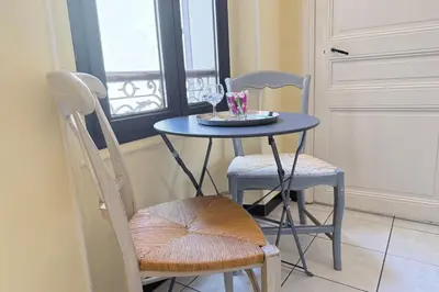 a blue table with two chairs and a table with wine glasses at Beautiful 2-bedroom apartment - near the Palais and the beaches in Cannes