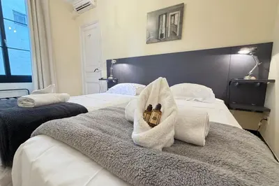 a hotel room with two beds with towels on them at Beautiful 2-bedroom apartment - near the Palais and the beaches in Cannes