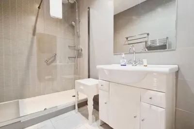 a white bathroom with a sink and a shower at Beautiful 2-bedroom apartment - near the Palais and the beaches in Cannes