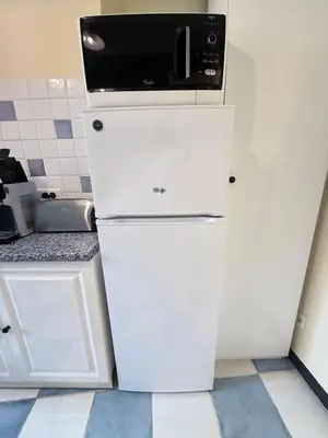 a white refrigerator with a microwave on top of it at Beautiful 2-bedroom apartment - near the Palais and the beaches in Cannes