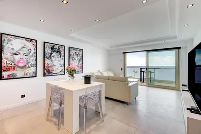 a living room with a table and a couch at Croisette sea view in Cannes