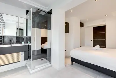a bedroom with a bed and a tub and a sink at Croisette sea view in Cannes