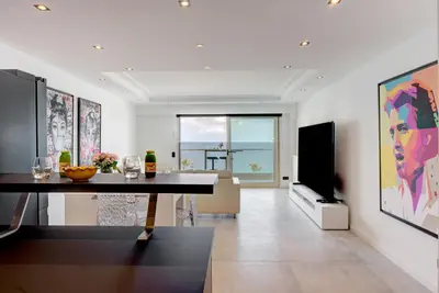 a living room with a table and a flat screen tv at Croisette sea view in Cannes