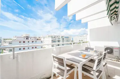 a white balcony with a table and chairs on it at Studio Velasquez - Welkeys in Cannes