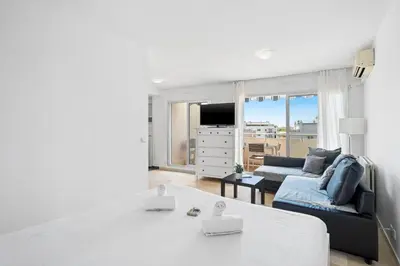 a living room with a couch and a tv at Studio Velasquez - Welkeys in Cannes