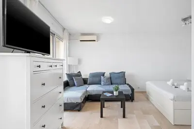 a living room with a couch and a flat screen tv at Studio Velasquez - Welkeys in Cannes