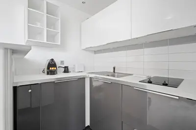 a white kitchen with a sink and a counter at Studio Velasquez - Welkeys in Cannes