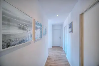 a hallway with pictures on the walls of a house at Downtown Cannes 2BR with AC & Terrace w Sea View - BENAKEY in Cannes