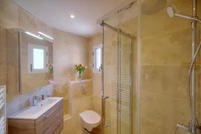 a bathroom with a shower and a toilet and a sink at Downtown Cannes 2BR with AC & Terrace w Sea View - BENAKEY in Cannes