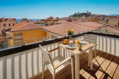 a table and chairs on a balcony with a view at Downtown Cannes 2BR with AC & Terrace w Sea View - BENAKEY in Cannes