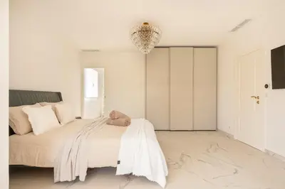 a bedroom with a bed and a chandelier at Villa California Cannes Private Pool in Cannes