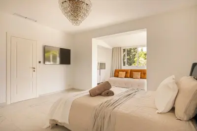 a white bedroom with a bed and a window at Villa California Cannes Private Pool in Cannes