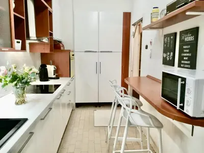 a kitchen with white cabinets and a counter with stools at en centre ville magnifique pied a terre ran44 in Cannes