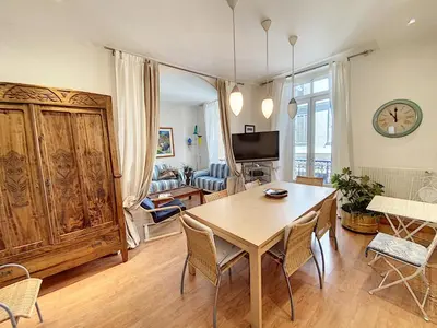 a living room with a wooden table and chairs at en centre ville magnifique pied a terre ran44 in Cannes