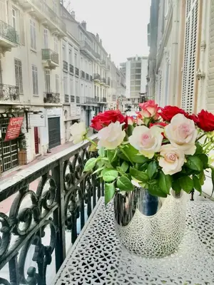 a vase filled with red and white roses on a balcony at en centre ville magnifique pied a terre ran44 in Cannes