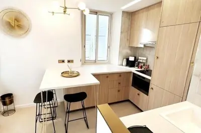 a small kitchen with a counter and stools in it at Palais Croisette Plage - 45 m2 Luxe - 2 Balcons in Cannes