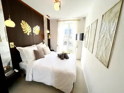a bedroom with a white bed with a black headboard at Palais Croisette Plage - 45 m2 Luxe - 2 Balcons in Cannes