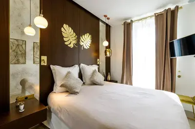 a bedroom with a large bed with white sheets and pillows at Palais Croisette Plage - 45 m2 Luxe - 2 Balcons in Cannes