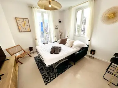 a bedroom with a bed in a room with windows at Palais Croisette Plage - 45 m2 Luxe - 2 Balcons in Cannes