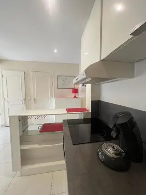 a kitchen with white cabinets and a black counter top at Sea view Croisette in Cannes