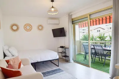 a bedroom with a bed and a sliding glass door at Palm Beach Studio with Terrace 150m from beaches in Cannes