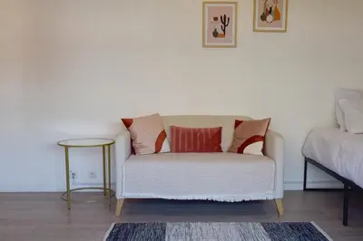a living room with a couch and a table at Palm Beach Studio with Terrace 150m from beaches in Cannes