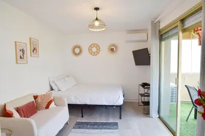 a living room with a bed and a couch at Palm Beach Studio with Terrace 150m from beaches in Cannes
