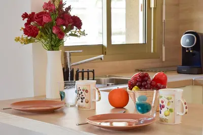 a kitchen counter with cups and plates and flowers at Palm Beach Studio with Terrace 150m from beaches in Cannes
