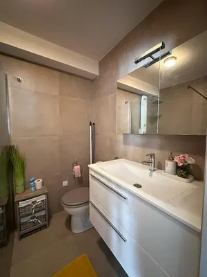 a bathroom with a sink and a toilet and a mirror at Un été à Cannes, Studio cosy à 10' de la Croisette in Cannes