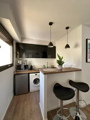 a kitchen with a counter and two bar stools at Un été à Cannes, Studio cosy à 10' de la Croisette in Cannes