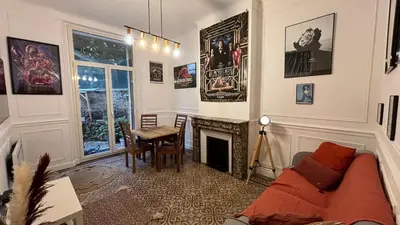a living room with a couch and a table and a fireplace at Appartement - Cannes proche Croisette avec jardin in Cannes