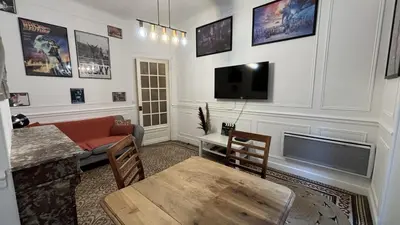 a living room with a couch a table and a tv at Appartement - Cannes proche Croisette avec jardin in Cannes